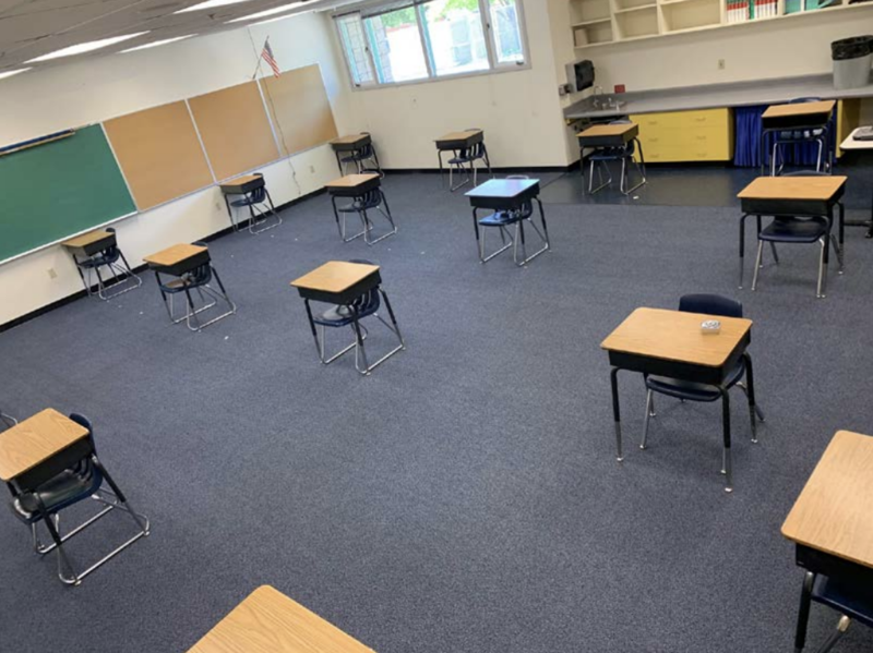escritorios colocados a distancia en una salón de clases