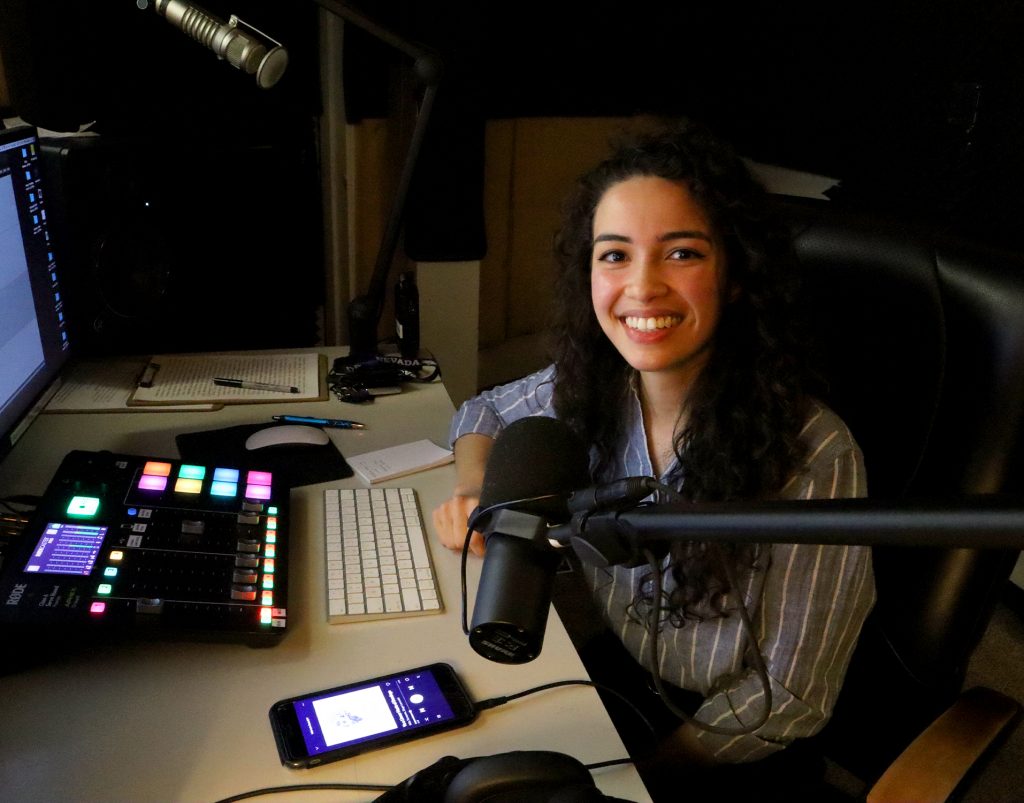 mujer sonriendo sentada en cabina de radio