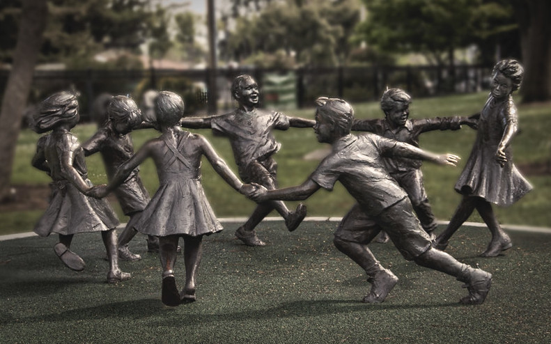 foto de la escultura de bronce con siete niños cogidos de la mano en círculo