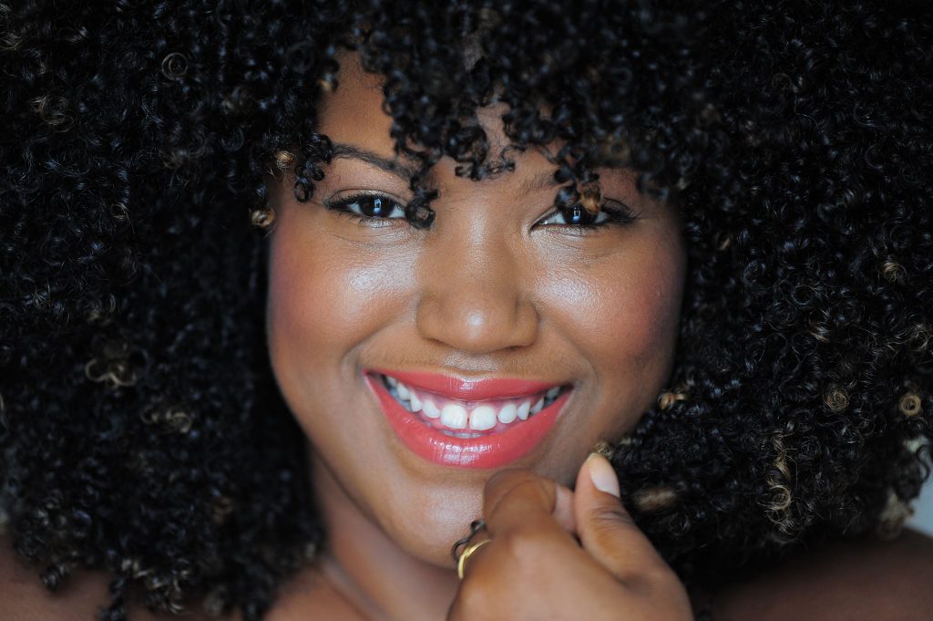 Mujer negra dominicana sonríe con su pelo rizo