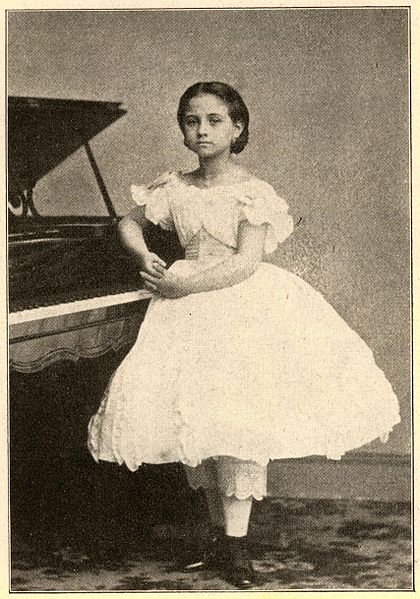 Una mujer joven junto a un piano