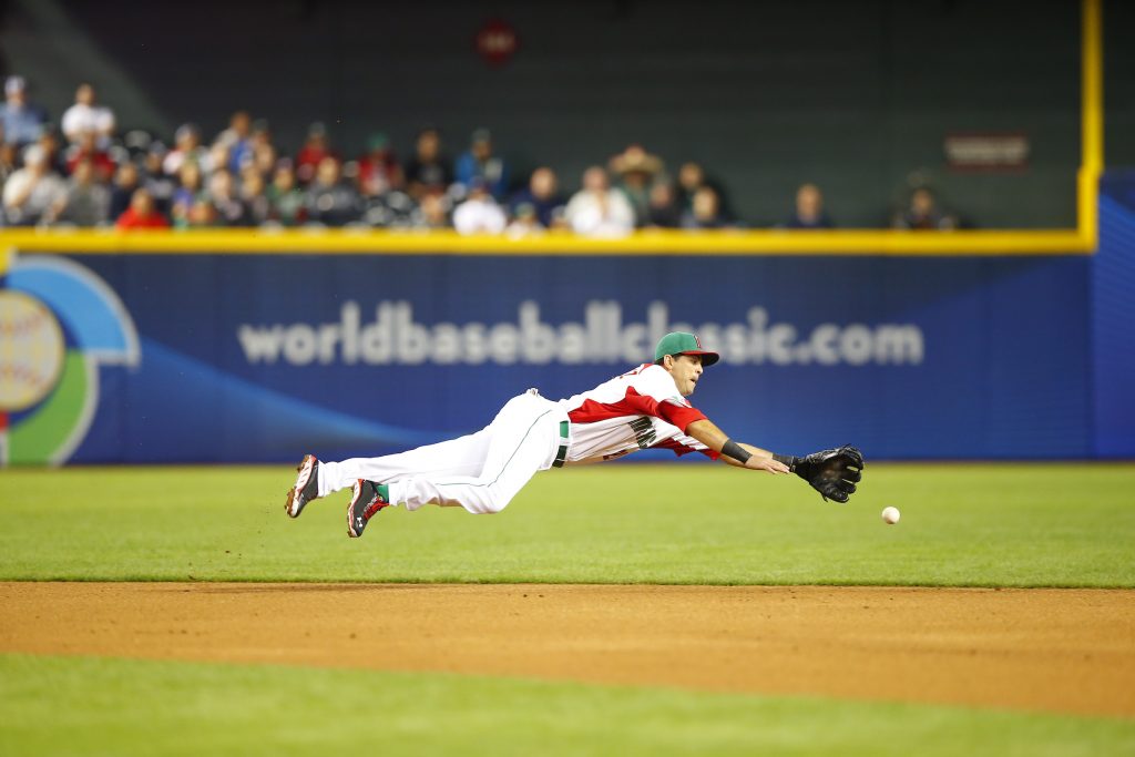 Gil Velázquez salta para atrapar la pelota en el campo