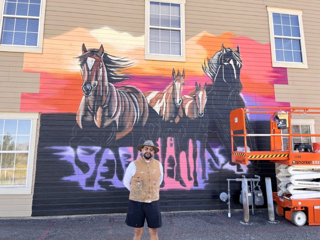 Un hombre enfrente una mural en Carson City
