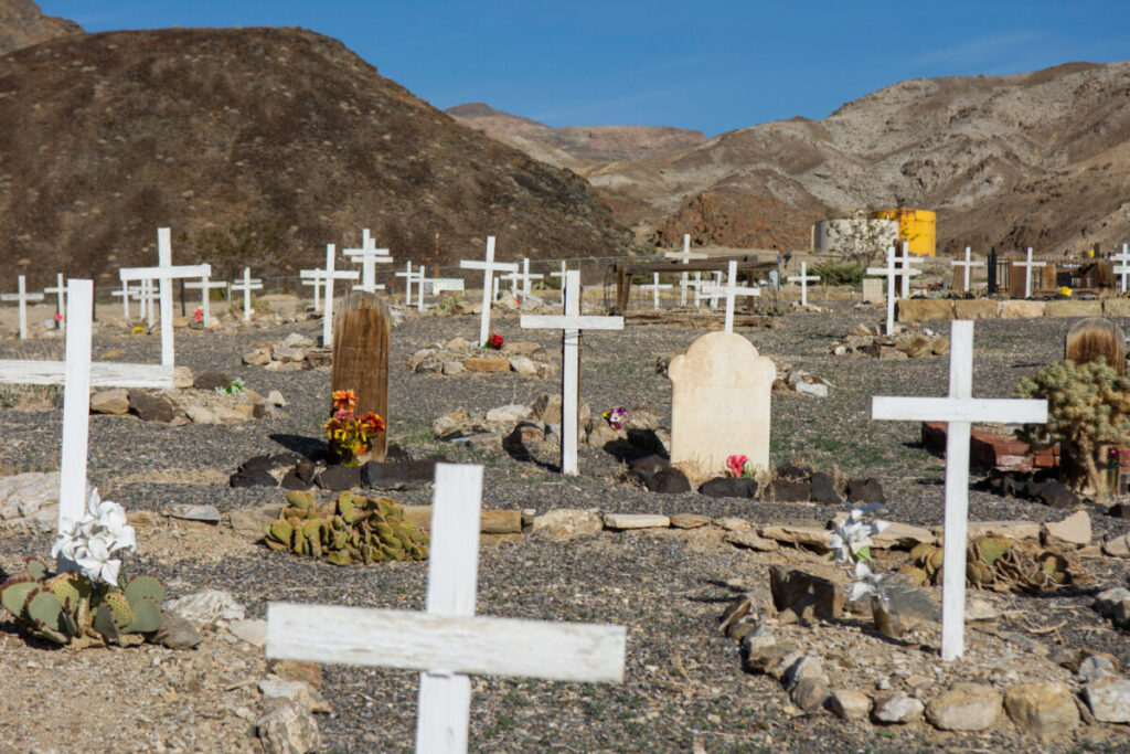 Las lápidas de un cementerio se muestran frente a las montañas.