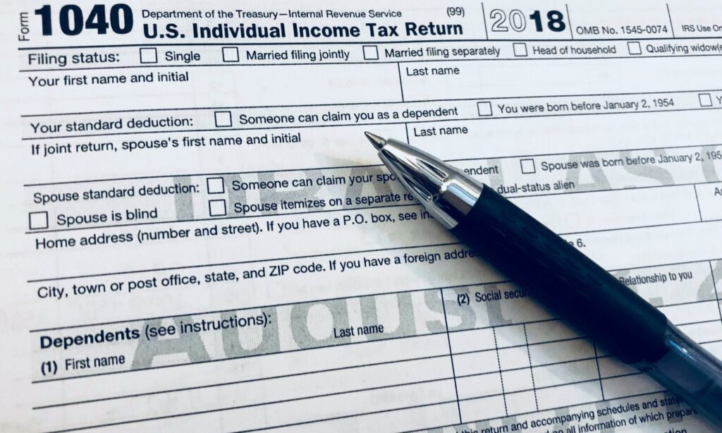 Se muestra un formulario de impuestos con un bolígrafo en primer plano.