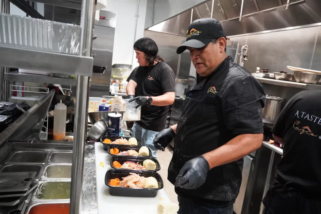 dos cocineros preparan platos para vender