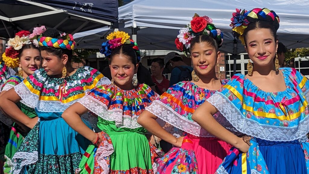 cuatro niñas vestidas con trajes coloridos