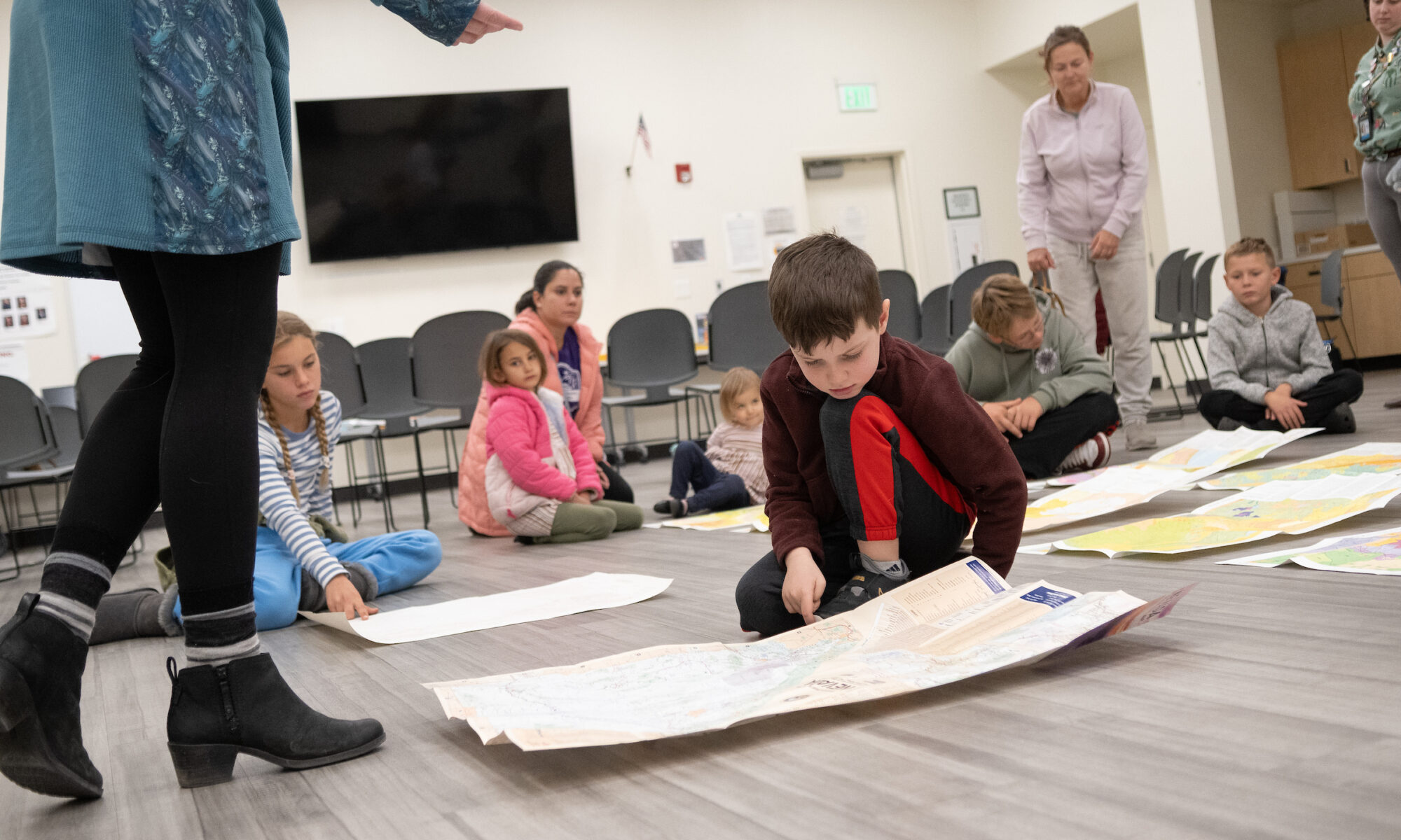 Niños en el piso mirando mapas