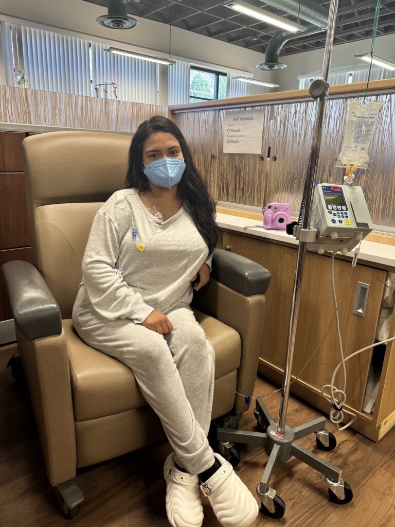 joven sentada con aparatos médicos y máscara tapaboca