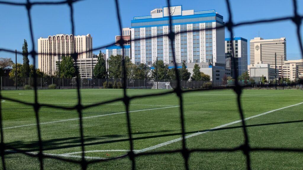 campo deportivo con hotel detrás