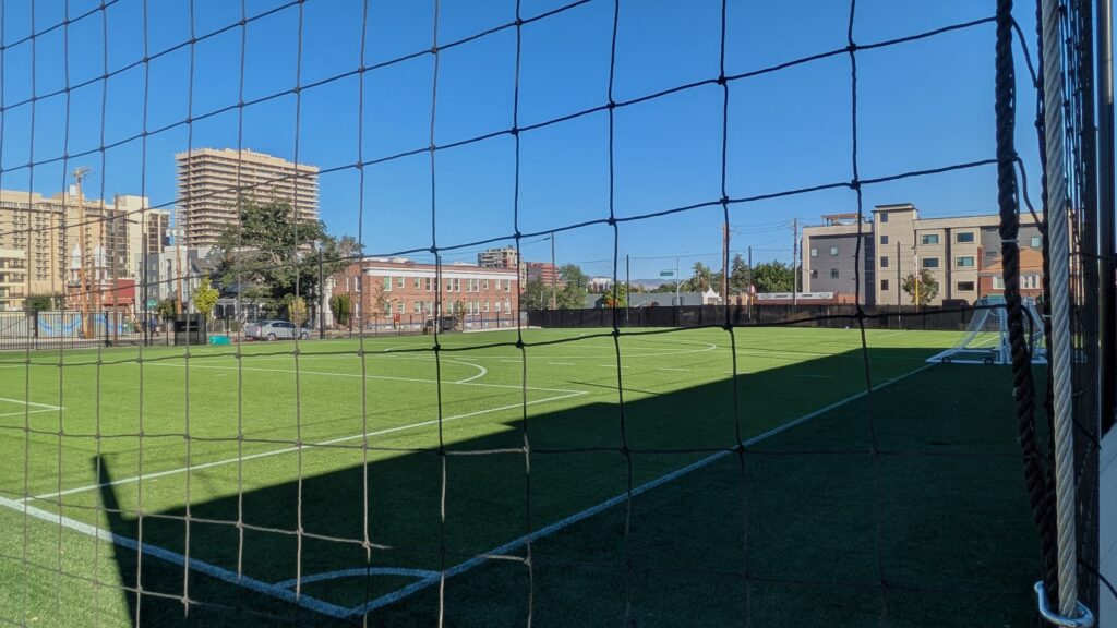un campo deportivo con edificios detrás