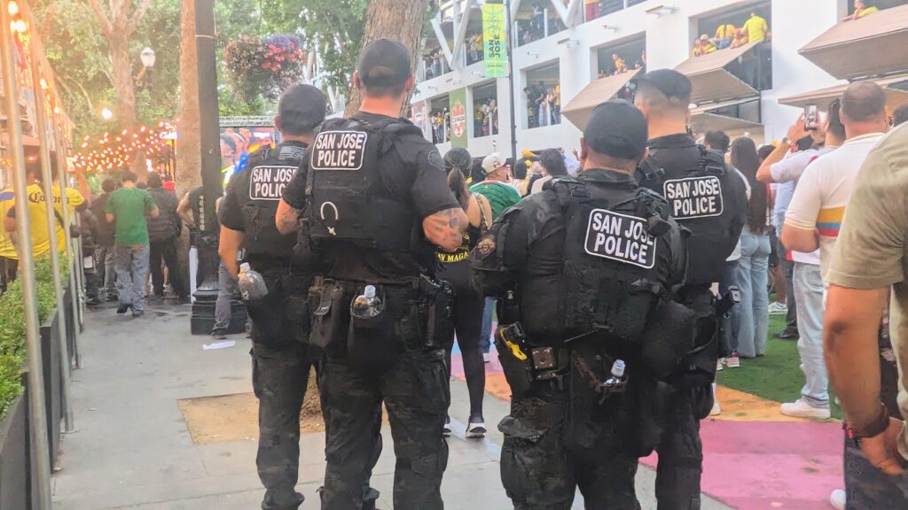 Cuatro agentes de la policía de San José vigilan a una multitud