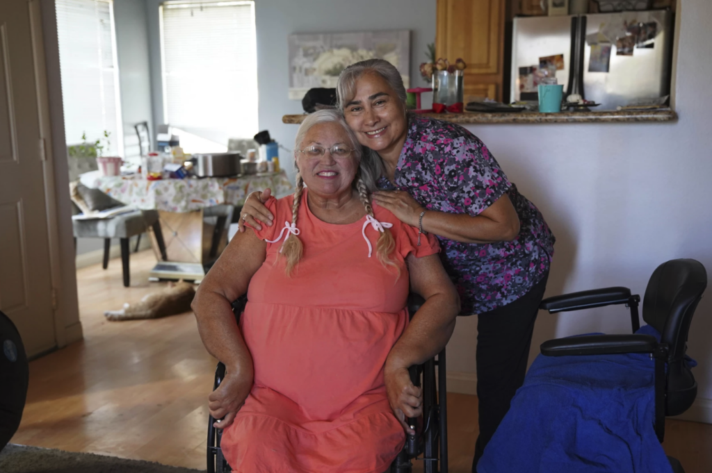 dos mujeres abrazadas mirando a la cámara