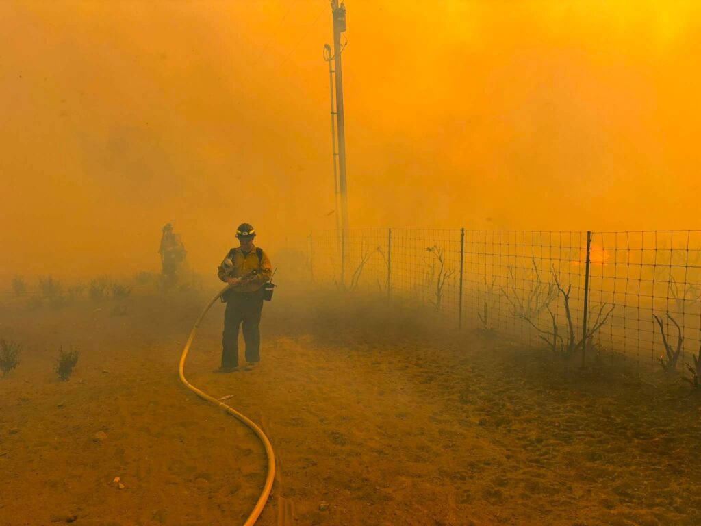 bombero riega agua con manguera