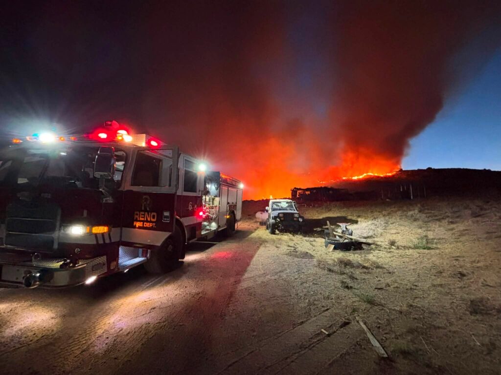 al fondo llamas de fuego y al trasfondo camiones de bomberos