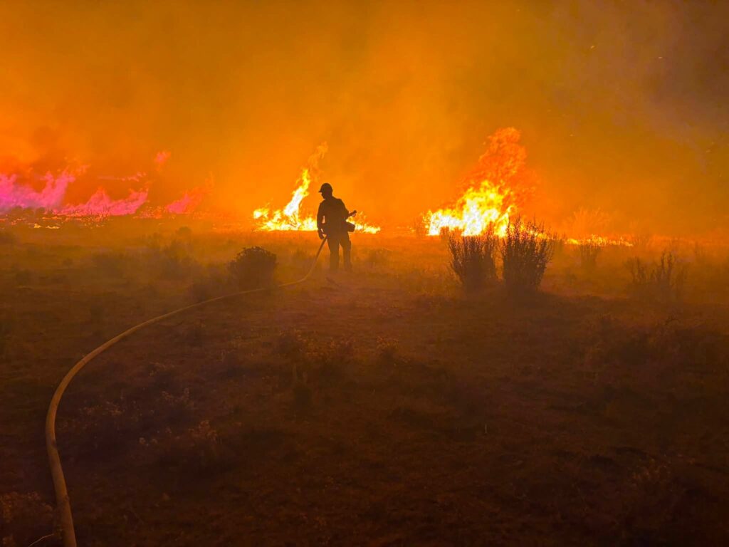bombero riega agua a llamas de fuego