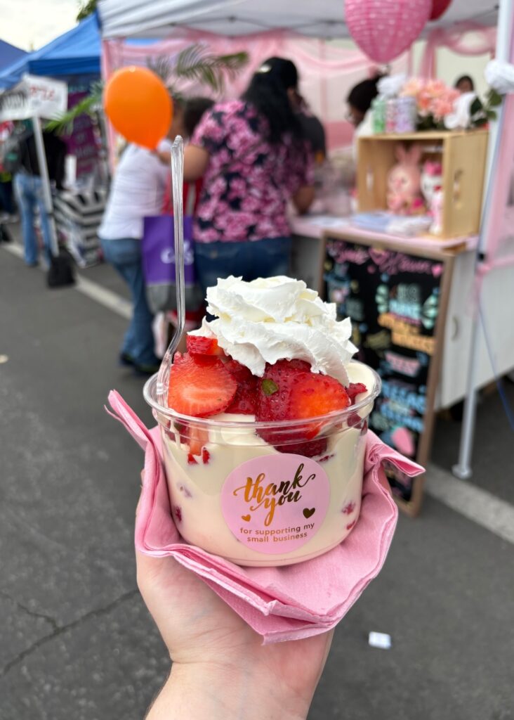 una taza llena de dulces y fresas de colores