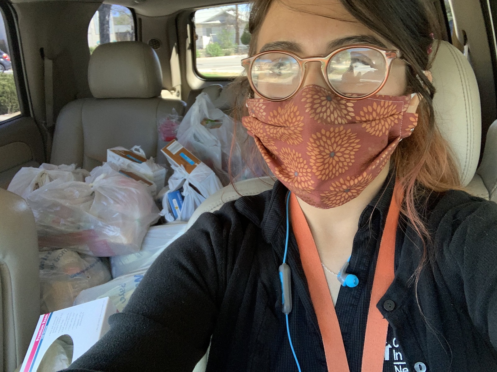 Carolina Juárez dirige la despensa de alimentos de la escuela primaria Glenn Duncan. Por la pandemia, comenzó a llevar alimentos a los hogares de las familias que necesitan ayuda. Esta selfie muestra a Juárez en su coche, con tapabocas, y las bolsas de comida atrás.