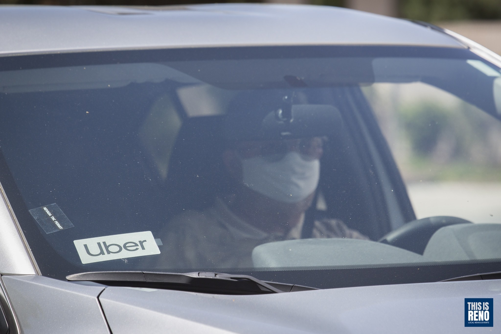 Un conductor de Uber usa una máscara mientras trabaja.