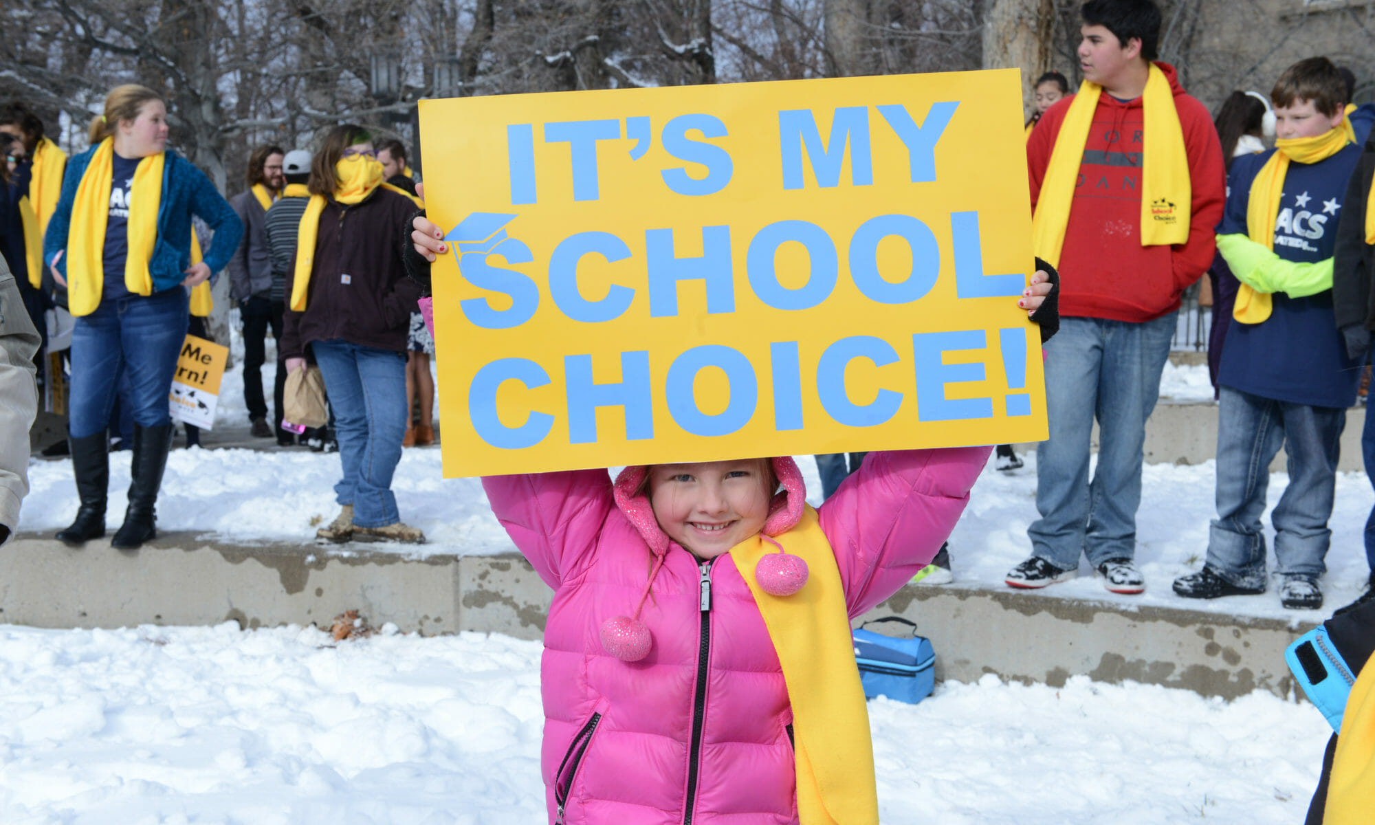 Niña alza cartel con palabras "es mi decisión escolar"