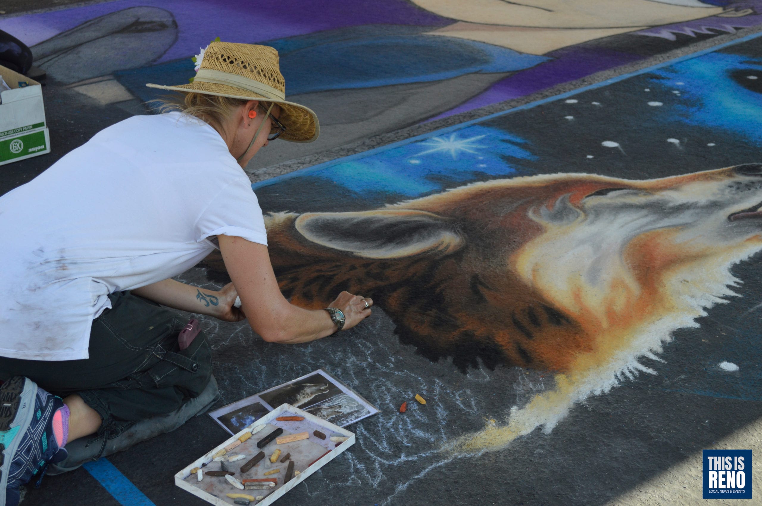 mujer arrodillada en calle pintando con tiza