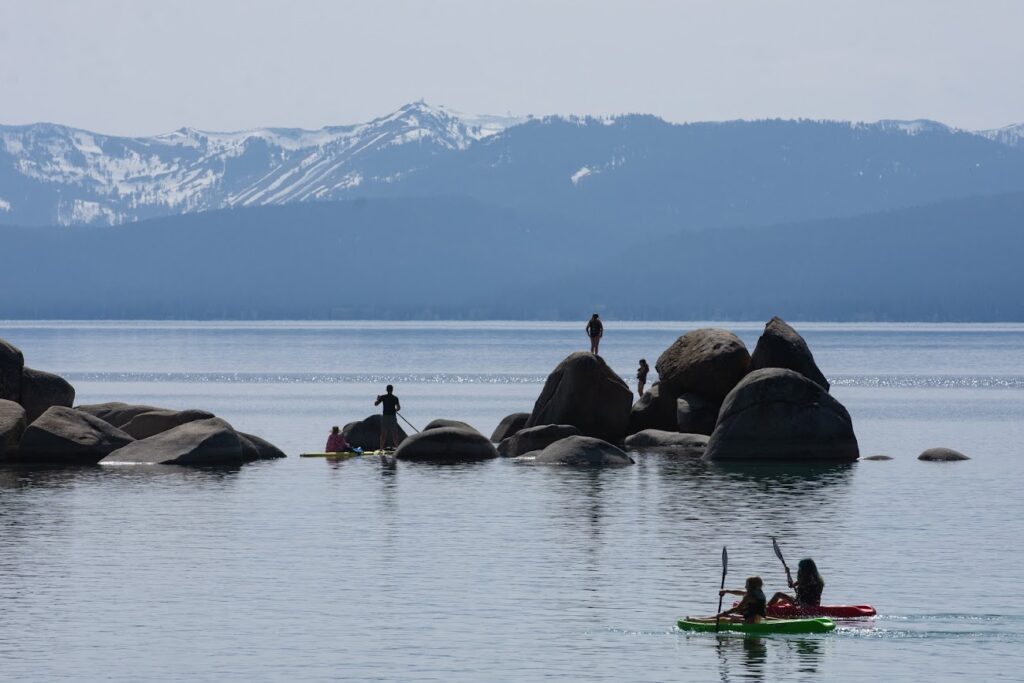 personas sobre rocas en lago