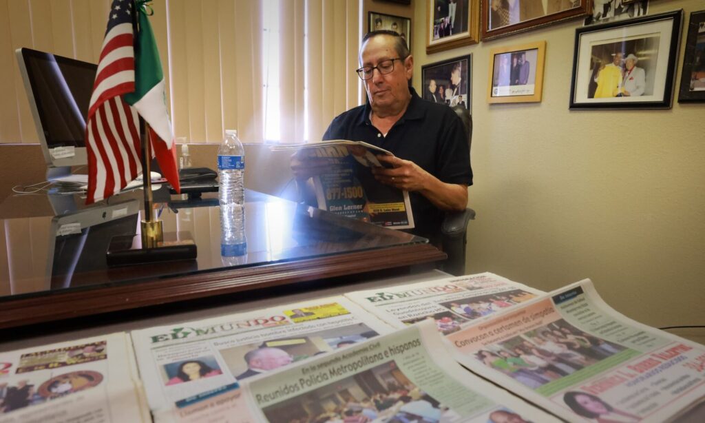 Eddie Escobedo Jr leyendo un periódico detrás de su escritorio