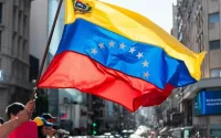 Hombre vuela la bandera venezolana en las calles de Buenos Aires.
