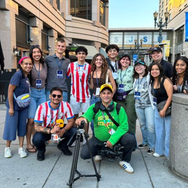 personas posan para un foto, algunos con camiseta roja y blanca