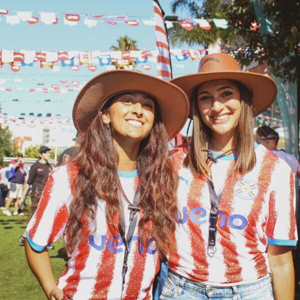 dos chicas portando playeras de Paraguay le sonríen a la cámara