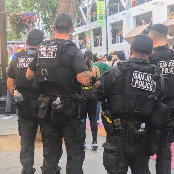 Cuatro agentes de la policía de San José vigilan a una multitud
