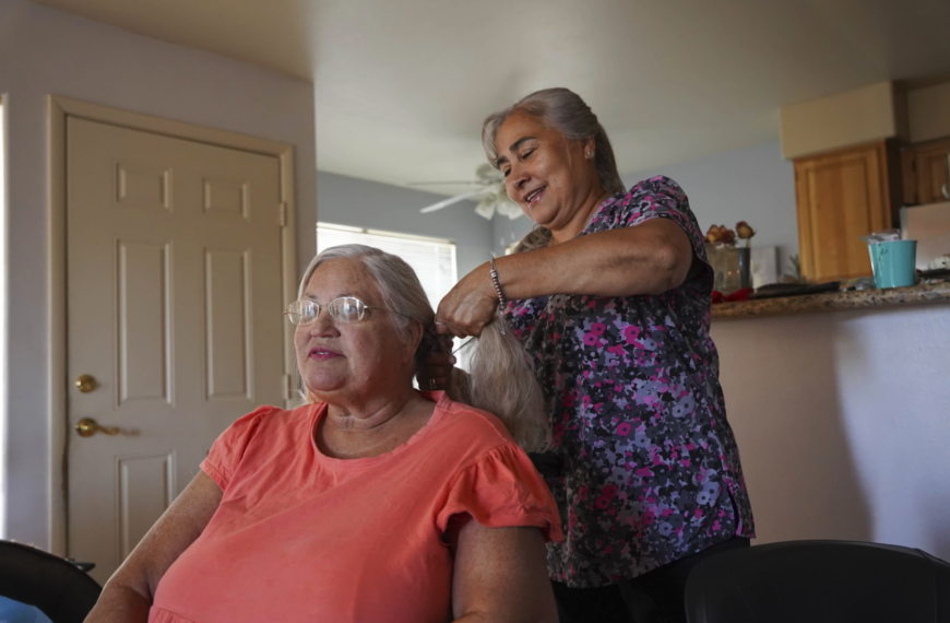 mujer hace trenzas en pelo de una mujer sentada