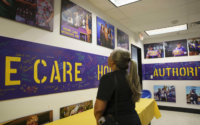 mujer mira a fotos colgadas en pared