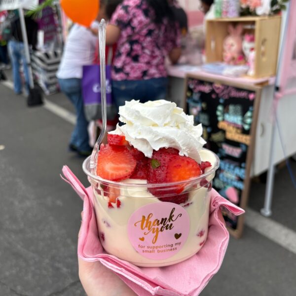 una taza llena de dulces y fresas de colores