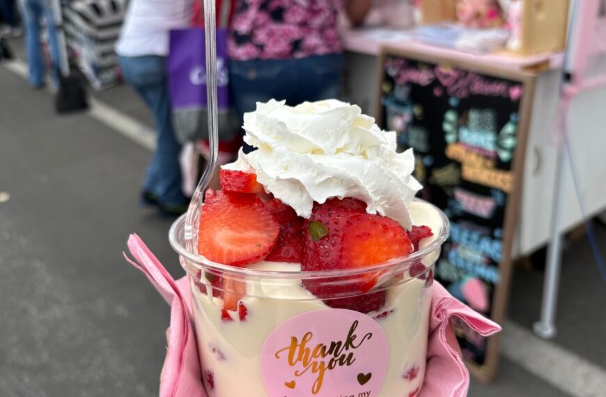 una taza llena de dulces y fresas de colores